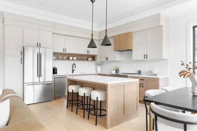 a kitchen with stainless steel appliances granite countertop a sink a stove a refrigerator and island with wooden floor