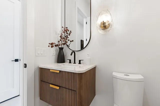 a bathroom with a sink and mirror with toilet