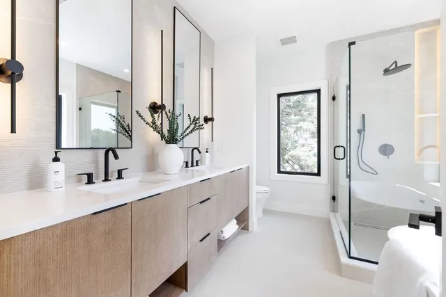 a bathroom with a double vanity sink a mirror a bathtub and shower