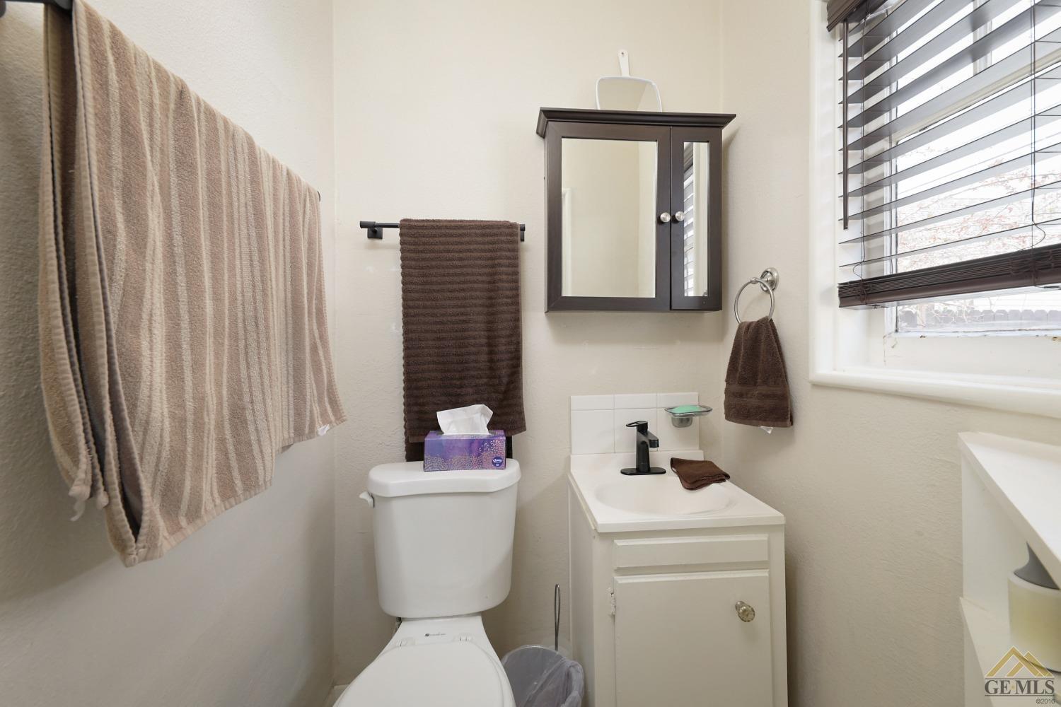 Undisclosed Address Bakersfield, CA 93305 - Photo 11 of 29 a bathroom with a toilet sink and mirror