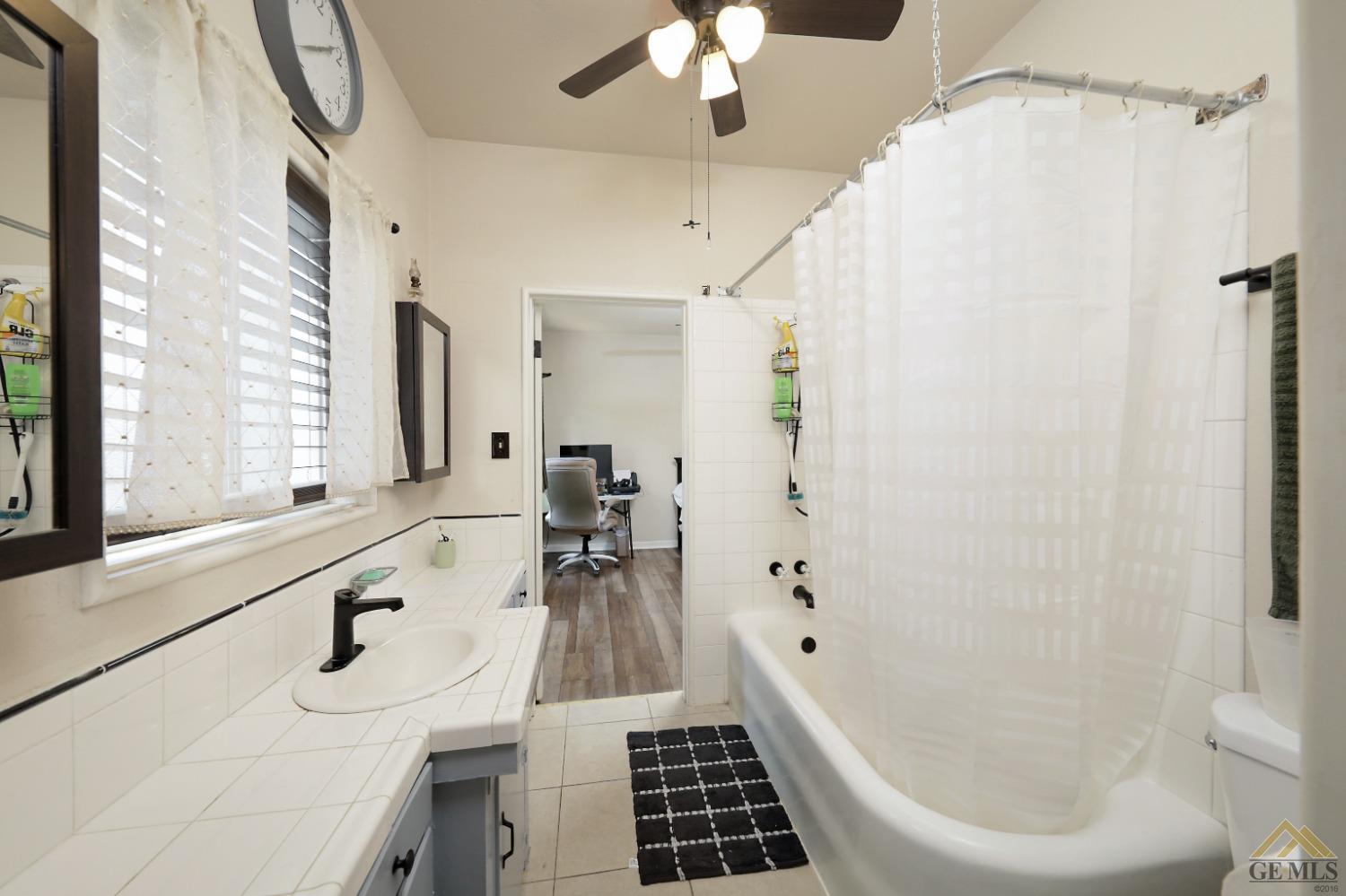 Undisclosed Address Bakersfield, CA 93305 - Photo 13 of 29 a bathroom with a bathtub a sink and a large mirror