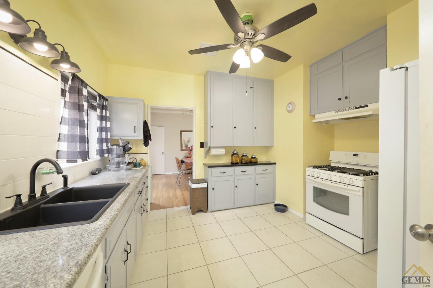 Undisclosed Address Bakersfield, CA 93305 - Photo 16 of 29 a kitchen with a sink stove and cabinets