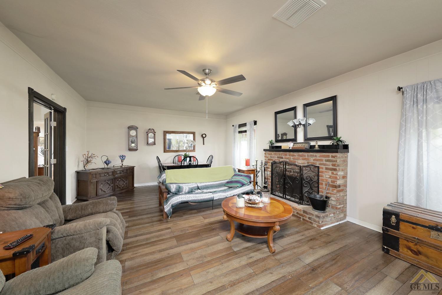 Undisclosed Address Bakersfield, CA 93305 - Photo 8 of 29 a living room with furniture a fireplace and wooden floor