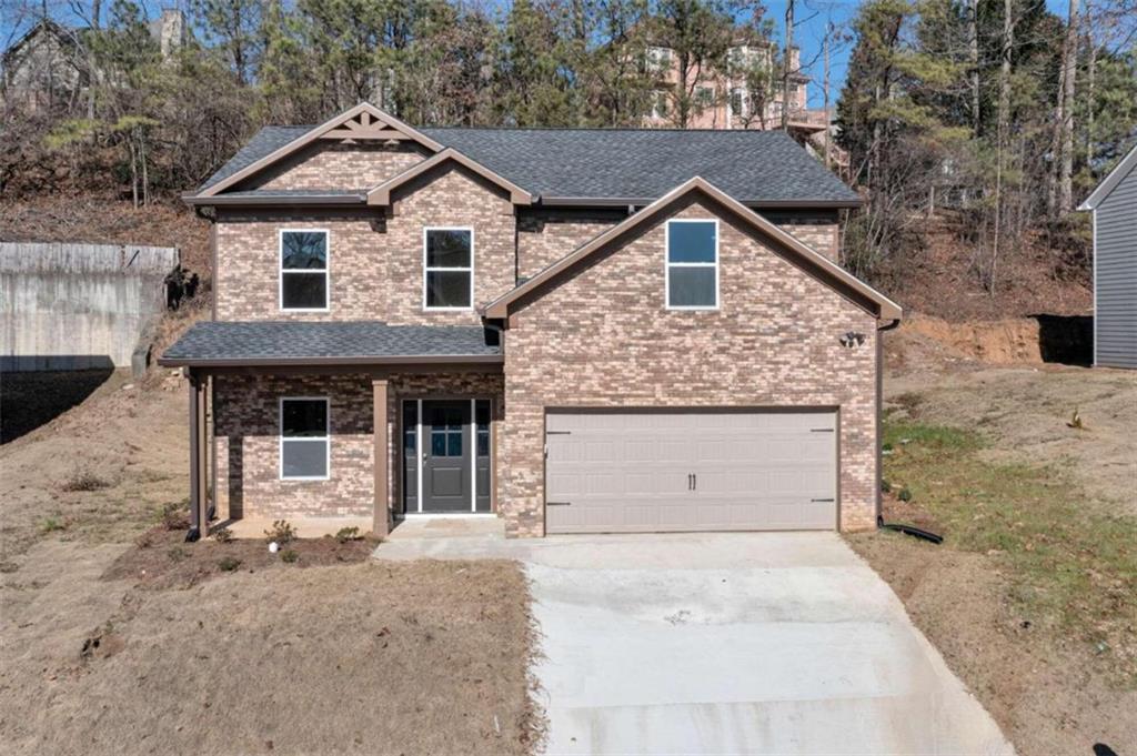 6932 Shadow Ridge Lane Stone Mountain, GA 30087 - Photo 1 of 1 a front view of a house with a yard and garage