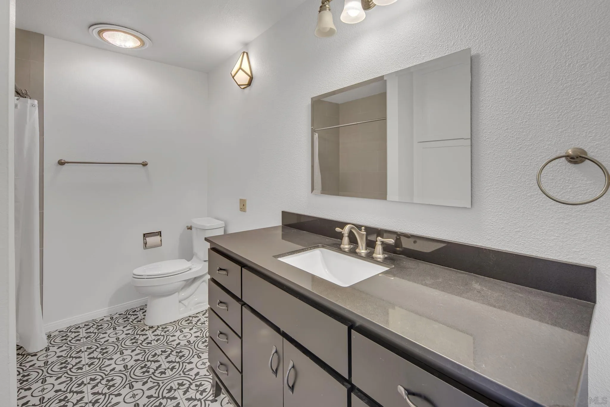 12544 Rios Road San Diego, CA 92128 - Photo 18 of 25 a bathroom with a granite countertop sink a toilet and a mirror