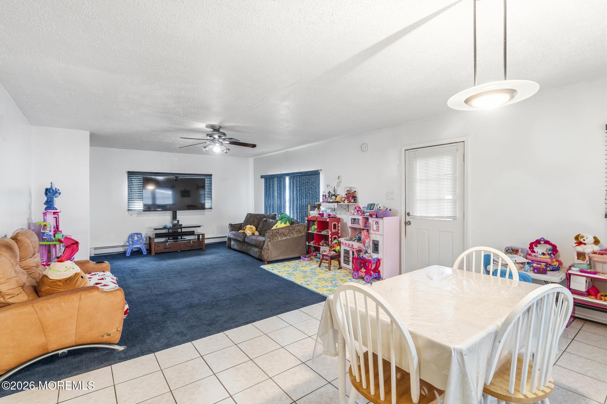 1914 Rutherford Avenue Neptune Township, NJ 07753 - Photo 14 of 25 a living room with furniture a flat screen tv and a dining table