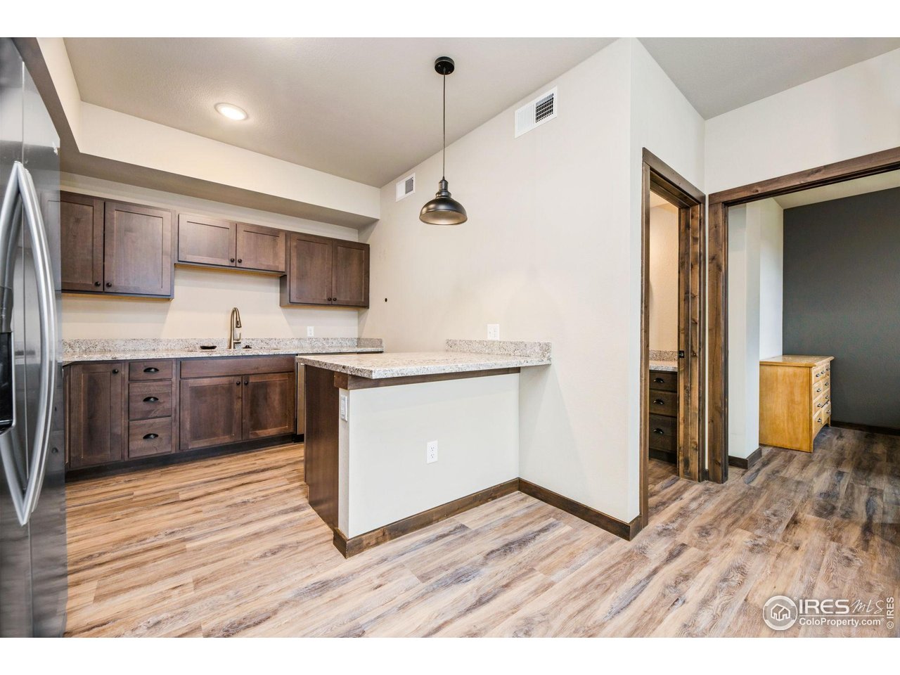 1734 Wildfire Road, Unit 102 Estes Park, CO 80517 - Photo 33 of 33 Open floorplan: Kitchen with breakfast bar, full bathroom to the right, and then bedroom.