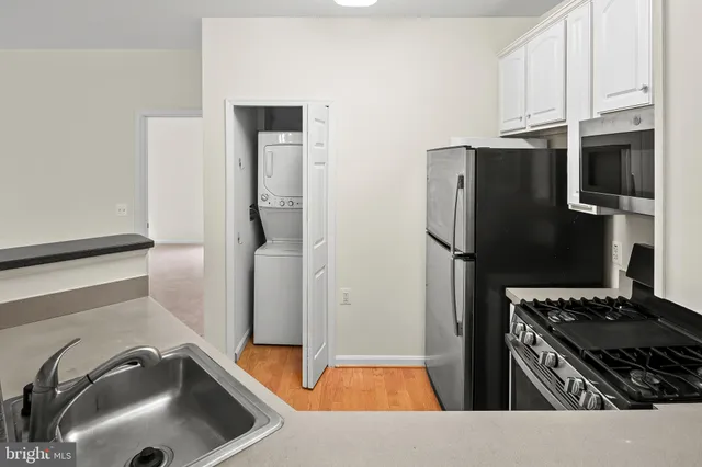 a kitchen with stainless steel appliances granite countertop a refrigerator and a sink