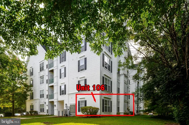 a view of a building with a yard and trees