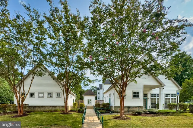 a front view of a house with a garden and trees