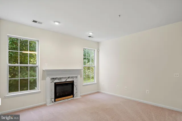 a view of an empty room with window and fire place
