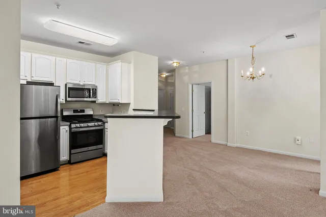 a kitchen with granite countertop a refrigerator and a stove top oven