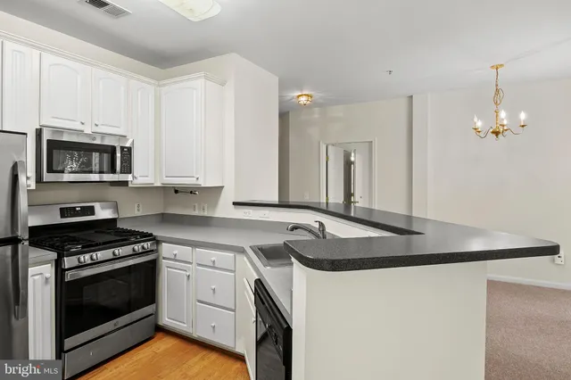 a kitchen with granite countertop a sink stove and microwave