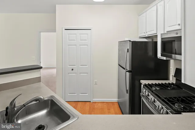 a kitchen with granite countertop a refrigerator and a sink
