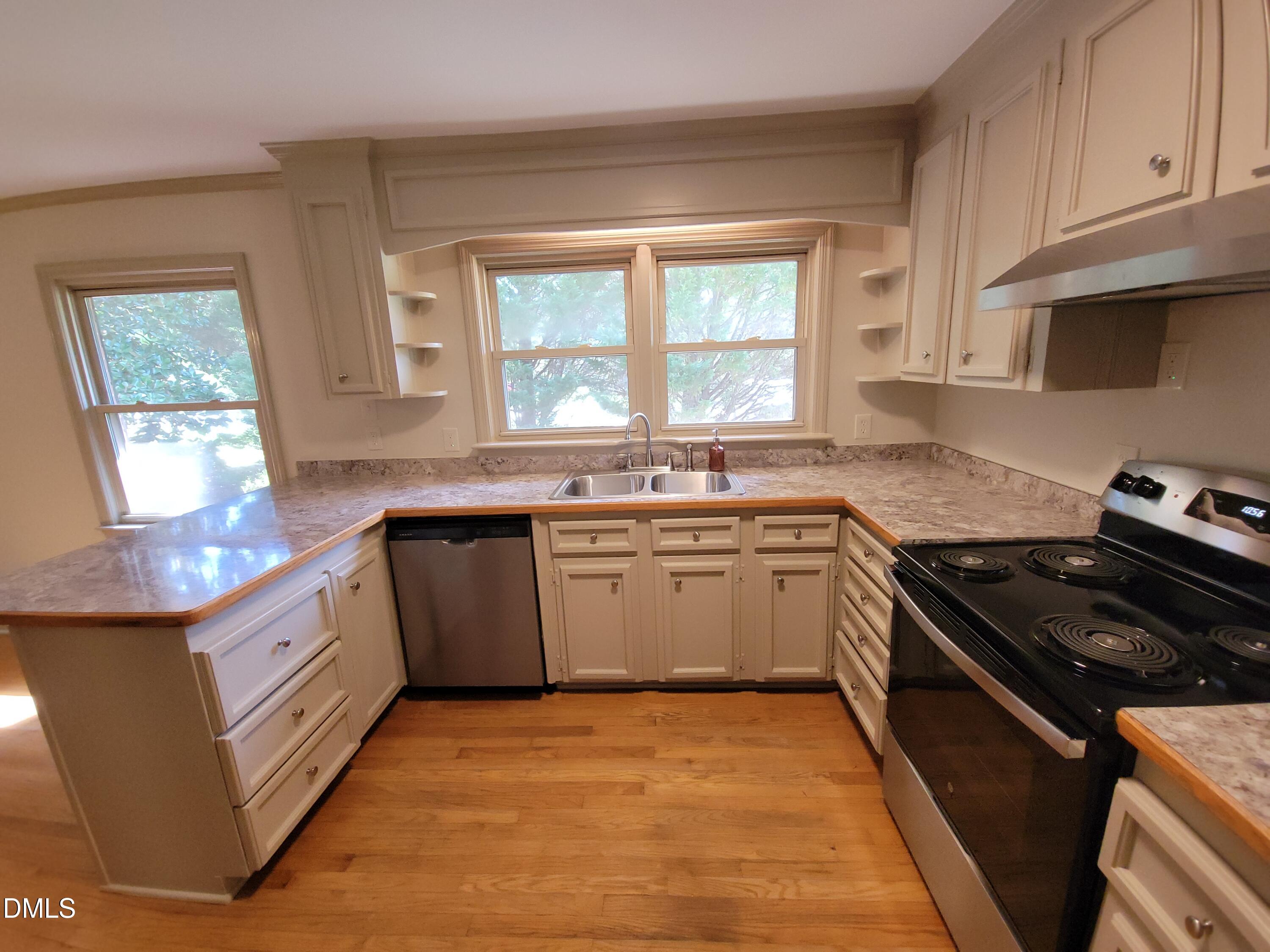 7000 Holly Springs Road Raleigh, NC 27606 - Photo 11 of 24 a kitchen with a sink stove top oven and cabinets