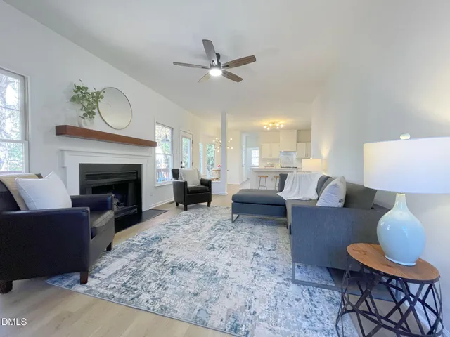 a living room with furniture fireplace and a large window