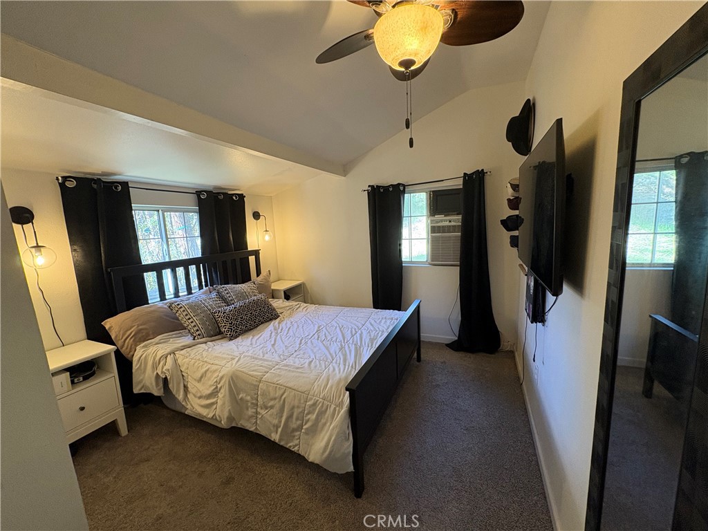 36750 Hilltop Road Yucaipa, CA 92399 - Photo 21 of 27 a bedroom with a bed dresser and a large mirror