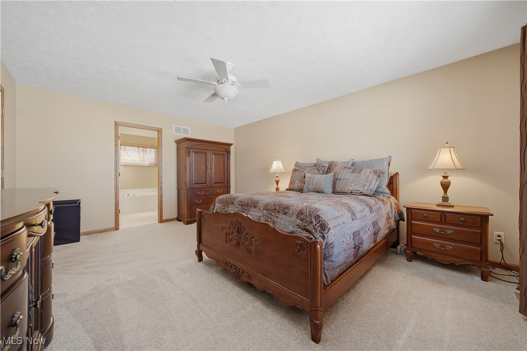 2132 Summerchase Road Northeast Canton, OH 44721 - Photo 23 of 49 Bedroom featuring light colored carpet, ceiling fan, a textured ceiling, and ensuite bathroom
