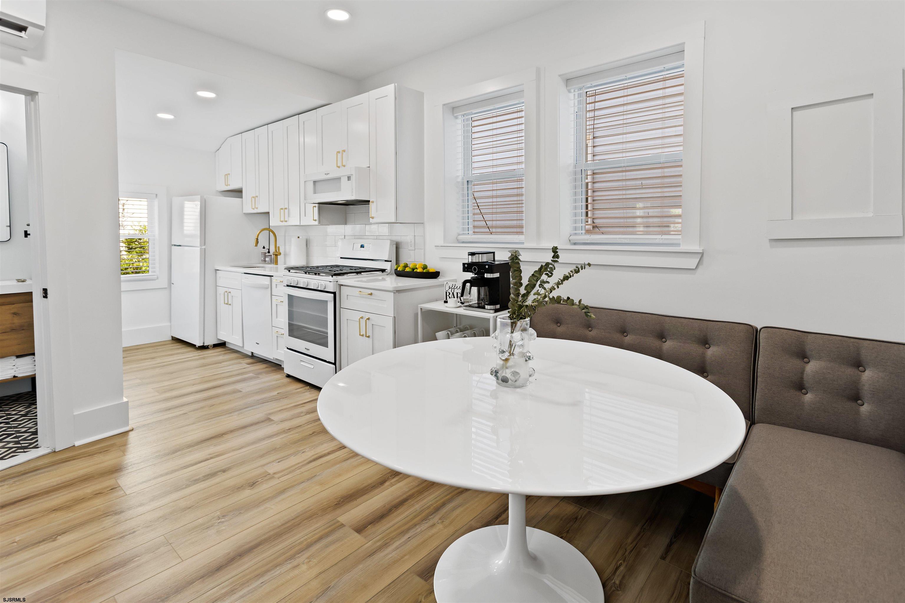1 South Delancy Place, Unit 1 Atlantic City, NJ 08401 - Photo 21 of 35 a kitchen with stainless steel appliances kitchen island granite countertop a sink a microwave dining table and chairs