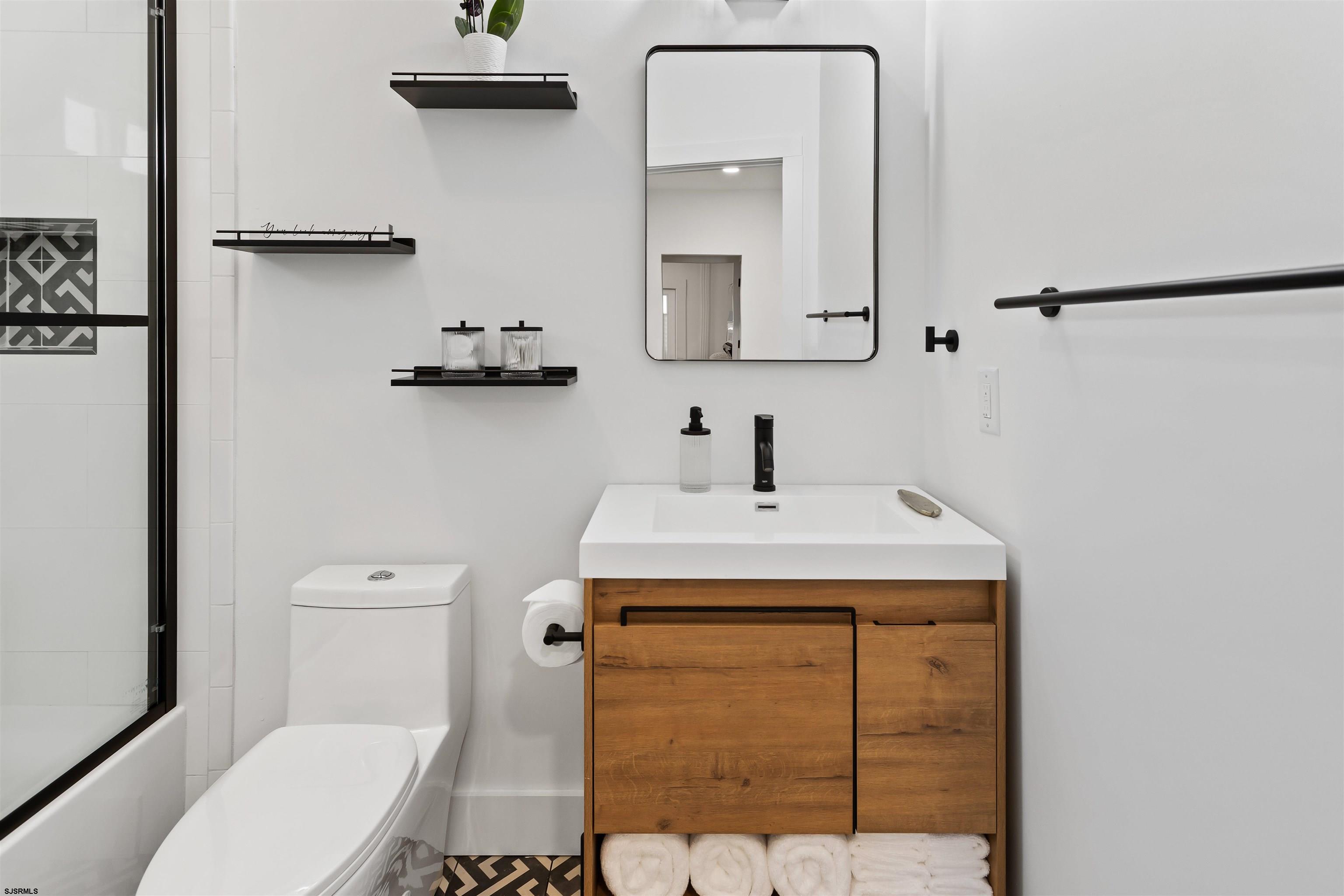 1 South Delancy Place, Unit 1 Atlantic City, NJ 08401 - Photo 28 of 35 a bathroom with a sink a toilet and a mirror