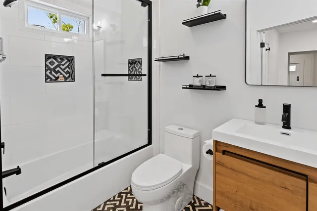 a bathroom with a sink a toilet and shower