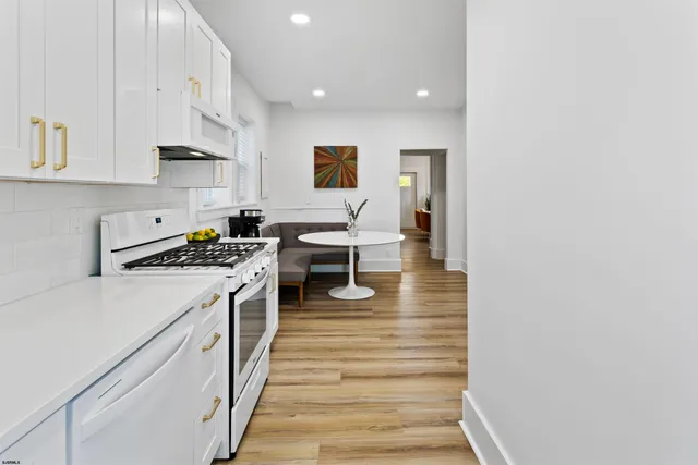 a kitchen with white cabinets and white appliances