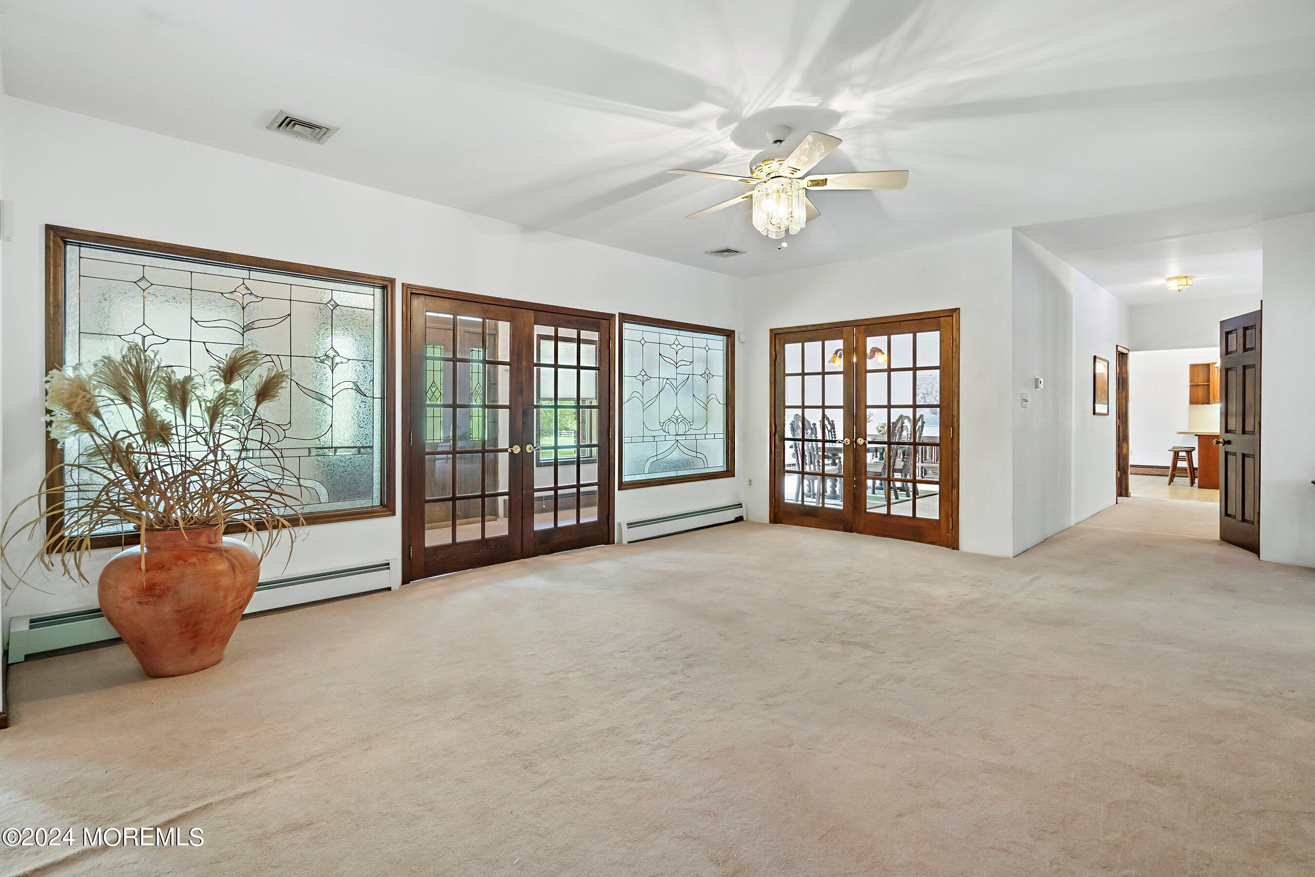 859 Monmouth Road Cream Ridge, NJ 08514 - Photo 16 of 50 a view of an empty room with chandelier fan and wooden floor