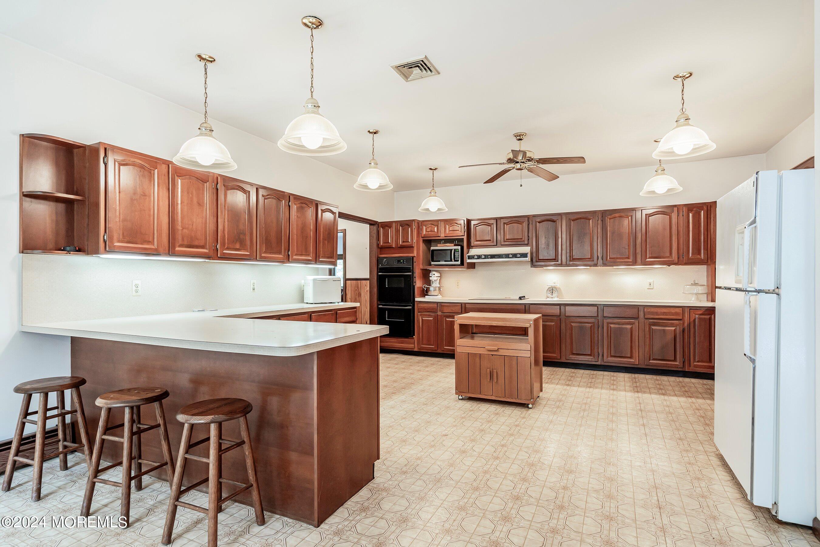 859 Monmouth Road Cream Ridge, NJ 08514 - Photo 5 of 50 a kitchen with stainless steel appliances granite countertop wooden cabinets a stove a sink and a refrigerator