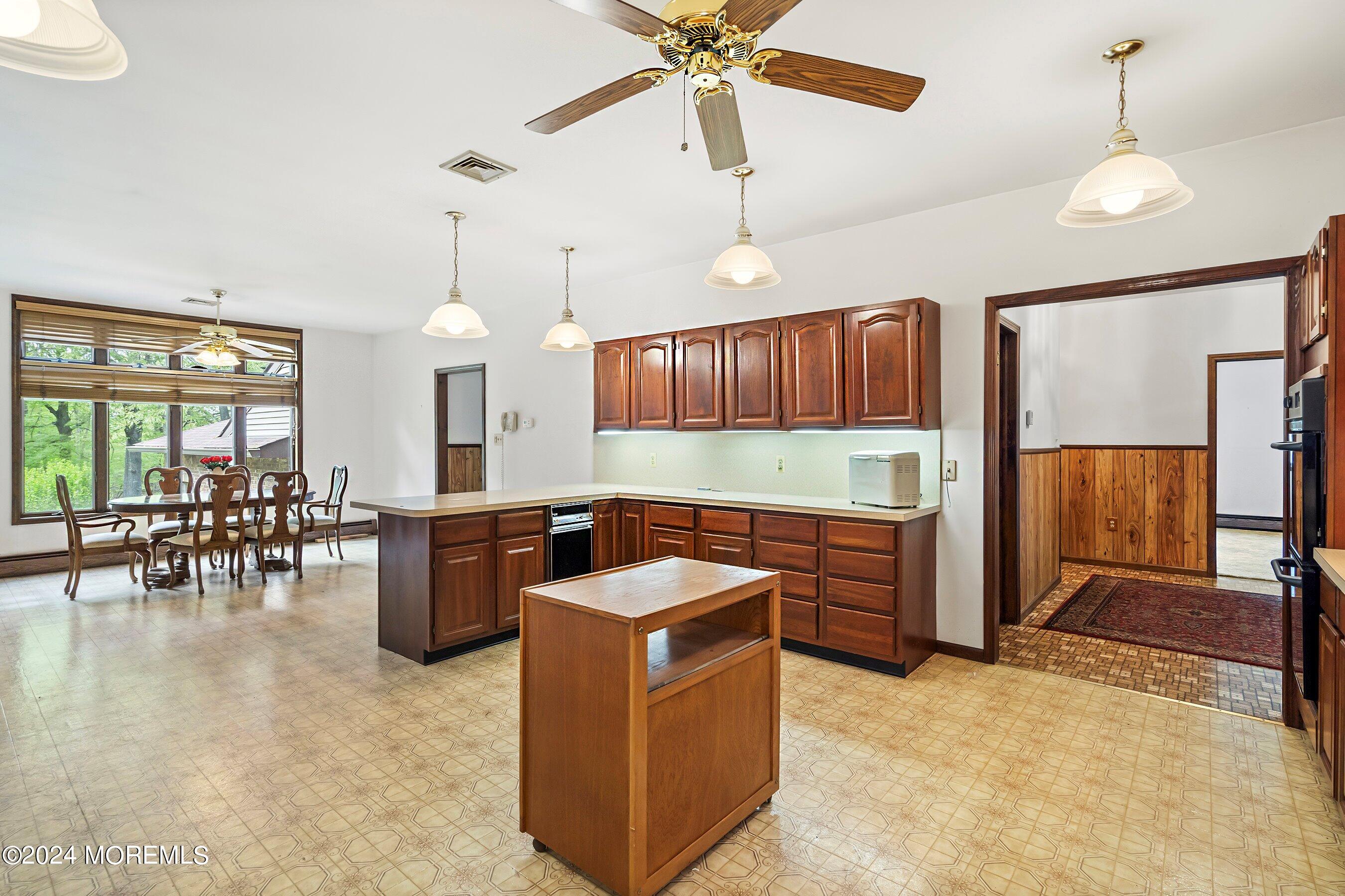 859 Monmouth Road Cream Ridge, NJ 08514 - Photo 6 of 50 a kitchen with a refrigerator a stove top oven a dining table and chairs with wooden floor