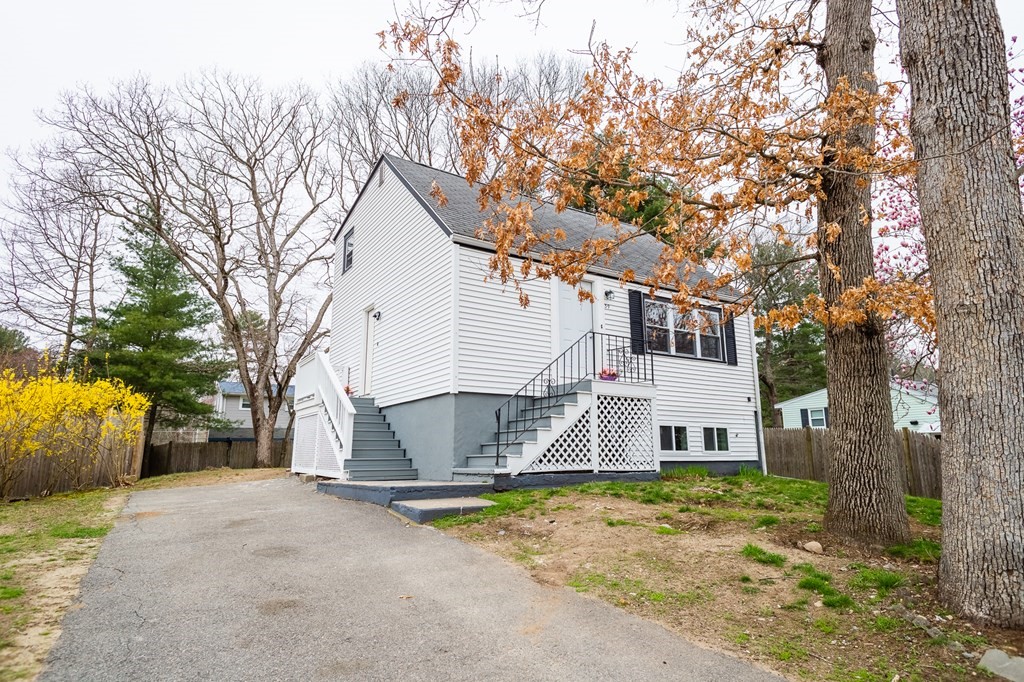 39 Kalmia Road Holbrook, MA 02343 - Photo 28 of 32 a view of a white house with a large tree and a yard