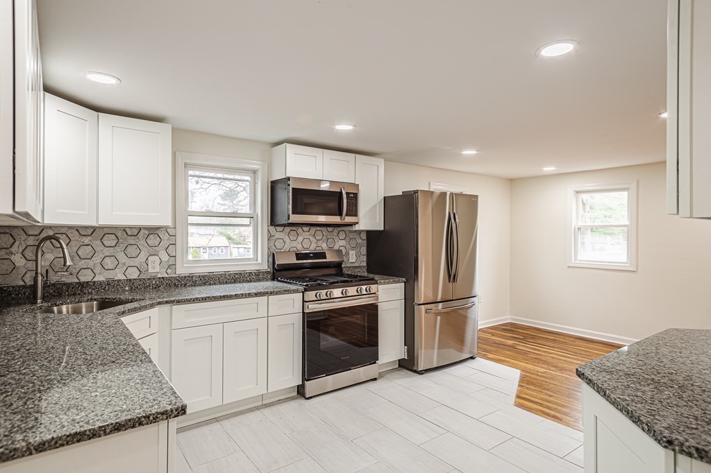 39 Kalmia Road Holbrook, MA 02343 - Photo 4 of 32 a kitchen with a sink a microwave a refrigerator and cabinets