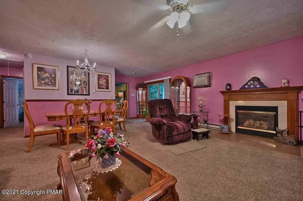 1607 Cotswald Road Tobyhanna, PA 18466 - Photo 5 of 61 a living room with furniture a fireplace and a flat screen tv