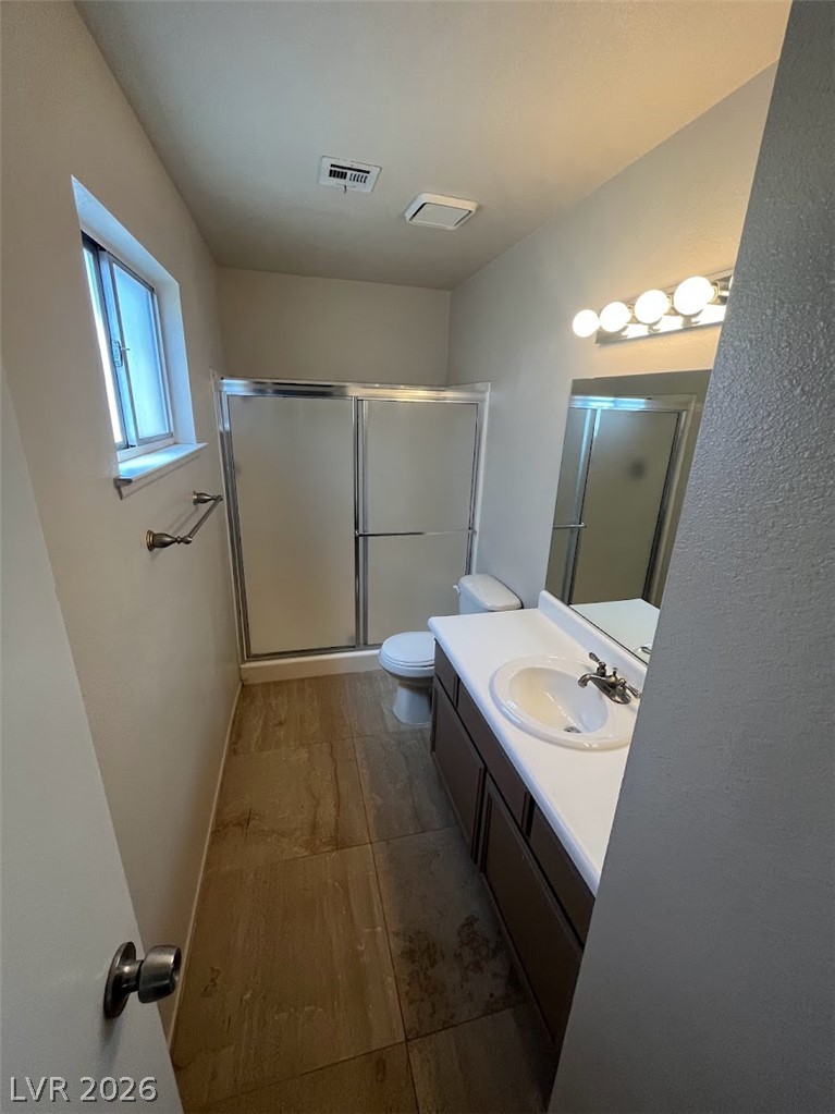 914 Scarlet Ridge Drive Las Vegas, NV 89128 - Photo 25 of 25 A well-lit bathroom features a vanity with a large mirror and a spacious shower.