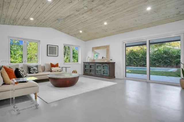 a living room with fireplace furniture and a large window