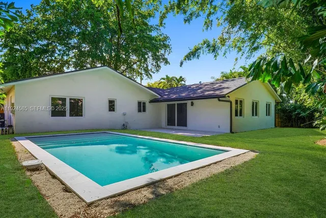 a view of a house with pool and a yard