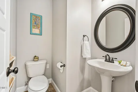 a bathroom with a toilet a sink and a mirror