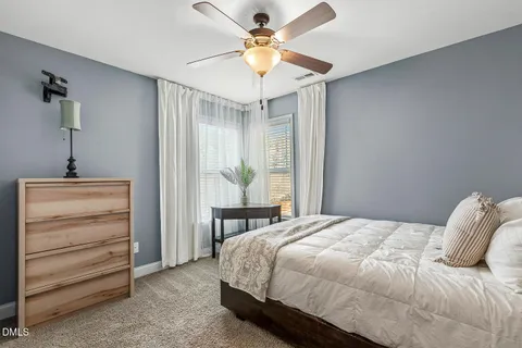 a bedroom with a bed and a ceiling fan