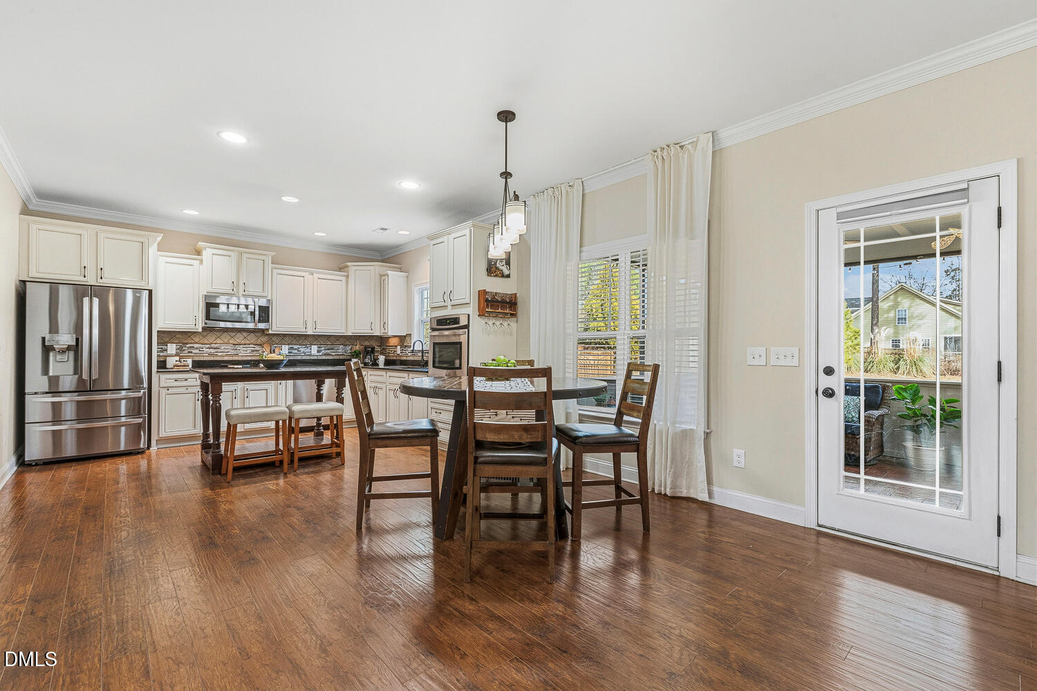 5933 Rounder Lane Holly Springs, NC 27540 - Photo 10 of 45 a kitchen with stainless steel appliances a dining table chairs and wooden floor