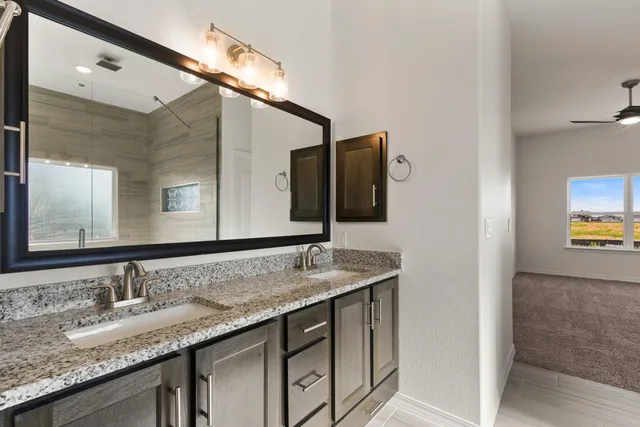 a bathroom with a granite countertop sink and a mirror