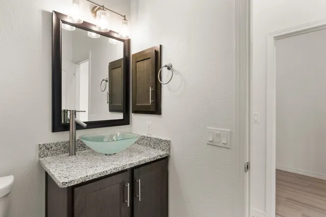 a bathroom with a granite countertop sink and a mirror