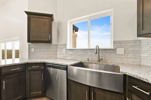 a kitchen with granite countertop a sink and cabinets