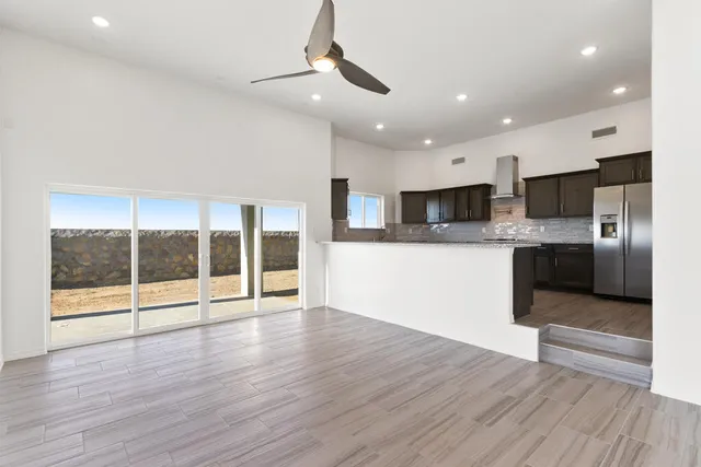 a view of a kitchen with a sink a refrigerator and wooden floor