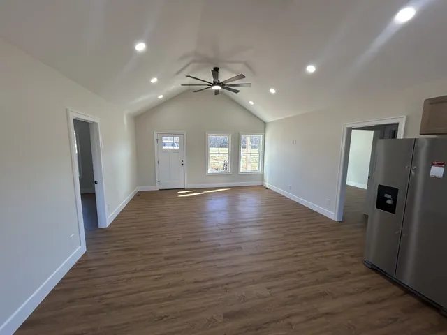 a view of a livingroom with wooden floor and staircase