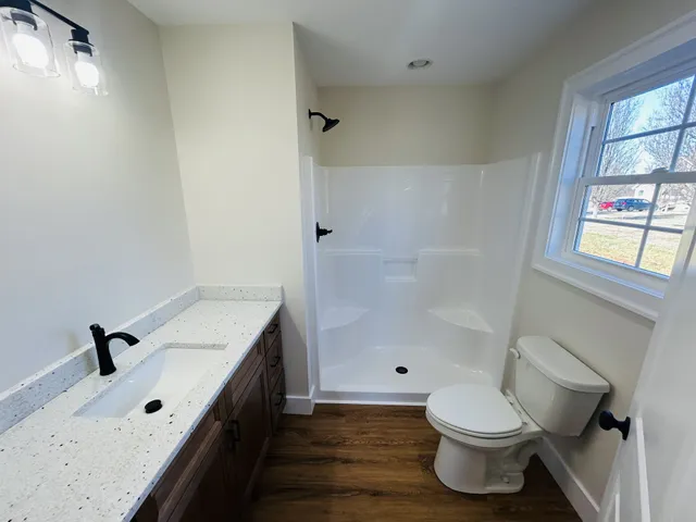 a bathroom with a double vanity sink toilet and shower