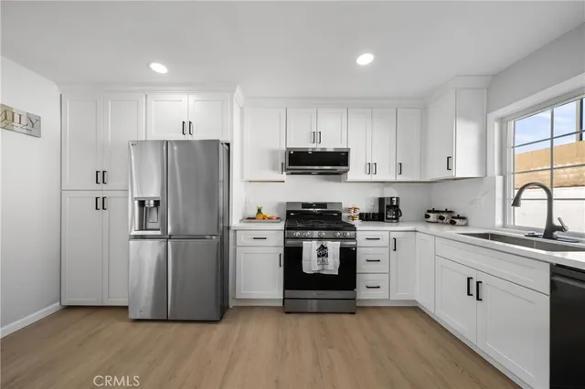a kitchen with stainless steel appliances a refrigerator sink and cabinets
