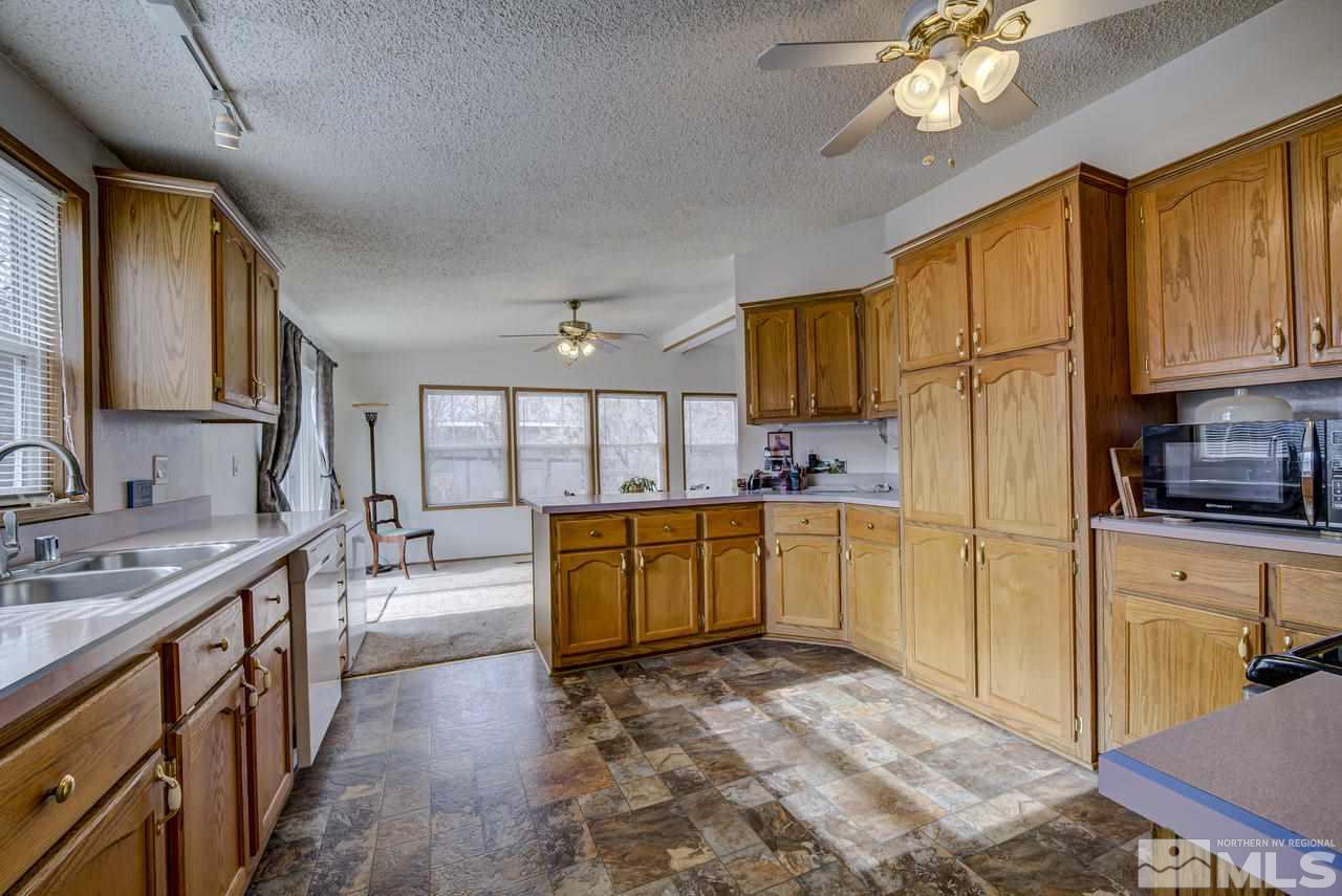 600 Theobald Reno, NV 89521 - Photo 12 of 25 a kitchen with a refrigerator a sink dishwasher stove and wooden cabinets