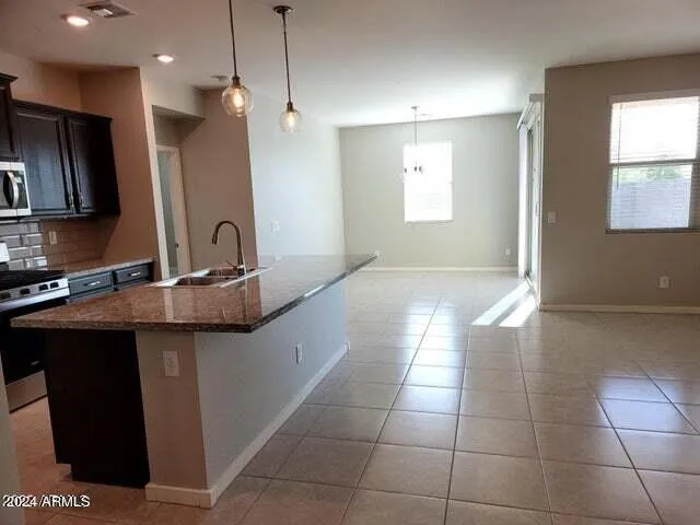 a kitchen with kitchen island granite countertop a sink a counter top space appliances and cabinets