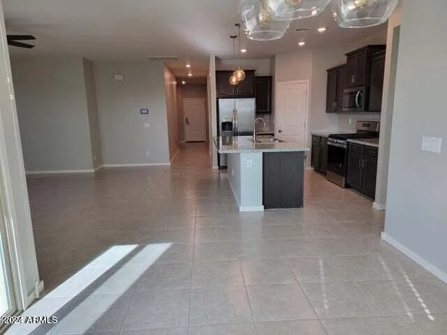 a large kitchen with stainless steel appliances a large counter top a stove and a refrigerator