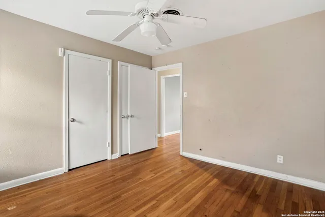 a view of an empty room with wooden floor