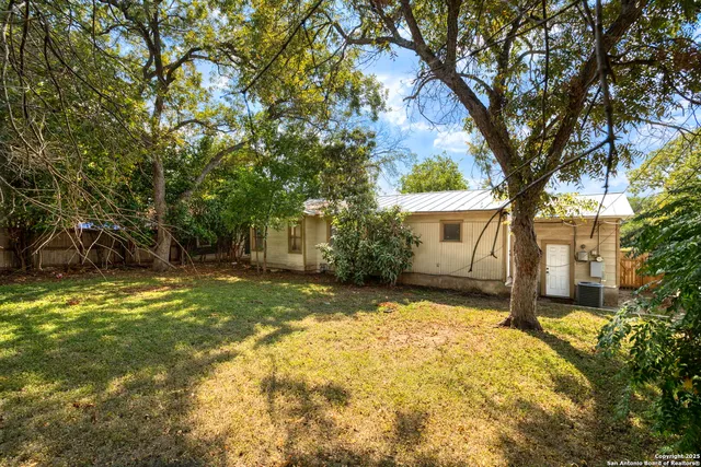 a view of a house with backyard and tree